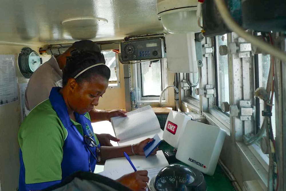 Woman checks documents on bridge of a ship. Photo: Francisco Blaha.