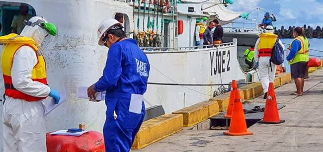 FFA was able to permit some monitoring and observation work to continue at fishing ports, such as this one at Apia, Samoa, by adopting COVID-safe protocols. Image shows workers on dock, some wearing personal protective equipment (PPE), next to fishing vessel moored alongside