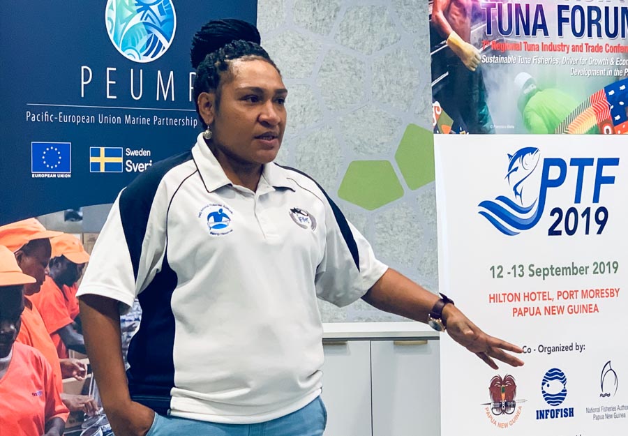 Rachael Luru, PIRFO observer and debriefer assessor for PNG Observer Programme, talking in front of posters