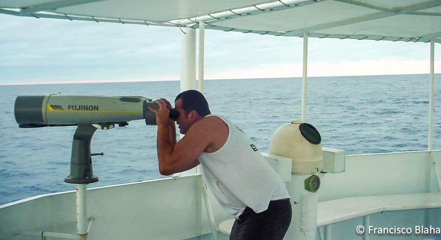 Francisco looking through telescope at work on board a purse seiner at Tokelau in 2002 (Photo: Francisco Blaha)
