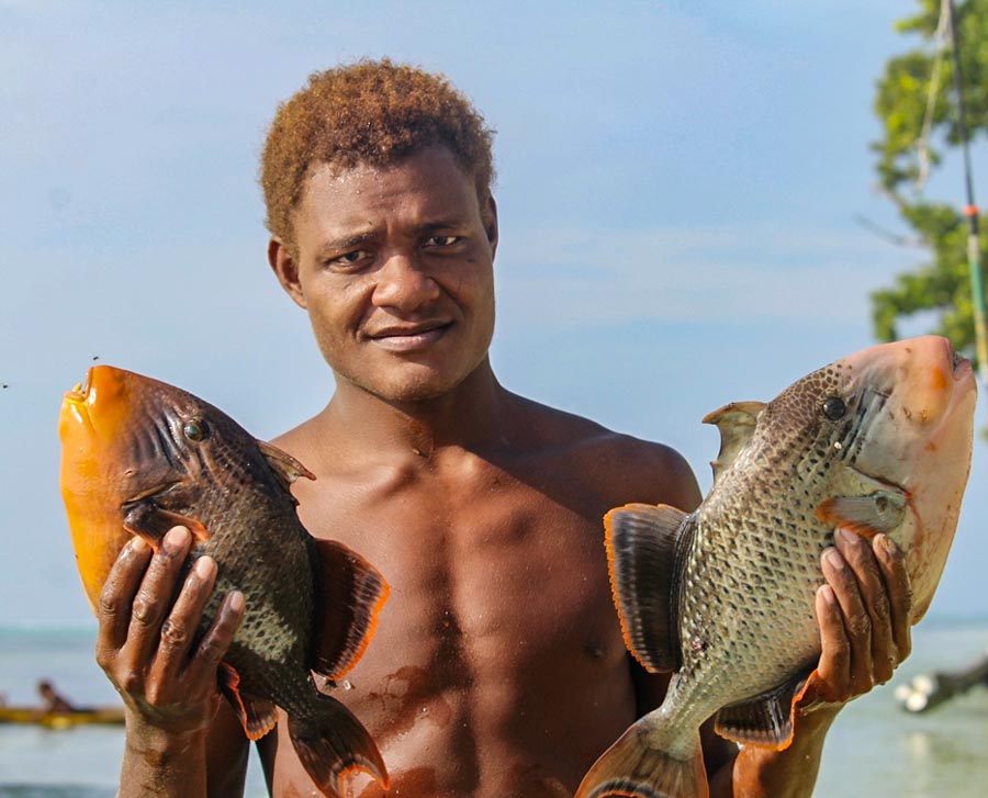 Fumamato’o man holds two fish of a species that was thought to be locally extinct. Photo WorldFish/Bira'au Wilson Saeni.