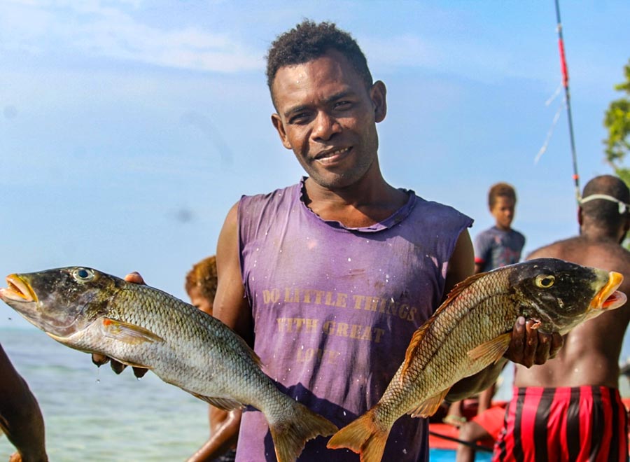 Fumamato'o villager with his catch of two fish. Photo: WorldFish/Bira'au Wilson Saeni.