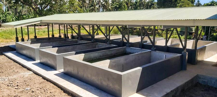 Newly built concrete pools, with roof, to be filled with water to hold tilapia, Aruligo hatchery, Guadalcanal